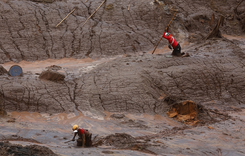 Rescue workers search for victims who were covered with mud after a dam owned by Vale SA and BHP Billiton Ltd burst in Mariana Brazil