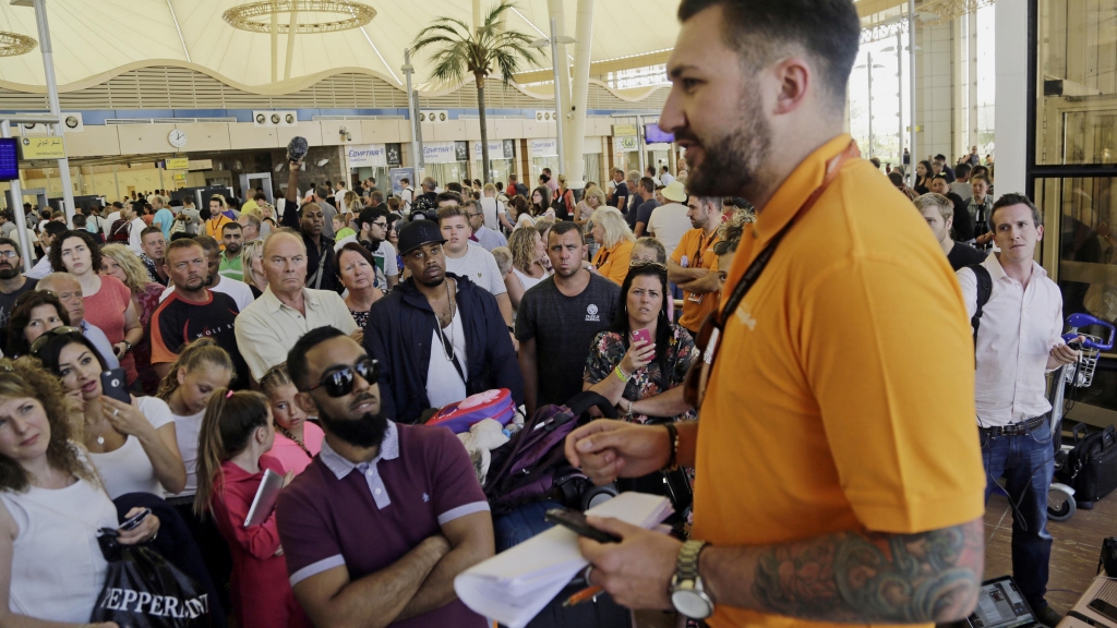 An Easy Jet agent talks to tourists stranded at Sharm el-Sheik's airport in Egypt Friday. The airline's plans to operate at least 10 flights out of the resort today were hampered by delays