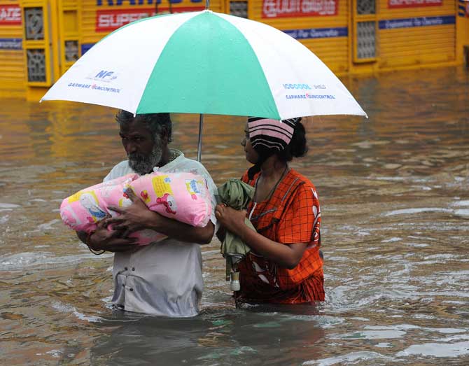 A family wades through floodwaters in Chennai on Wednesday. Pic  AFP