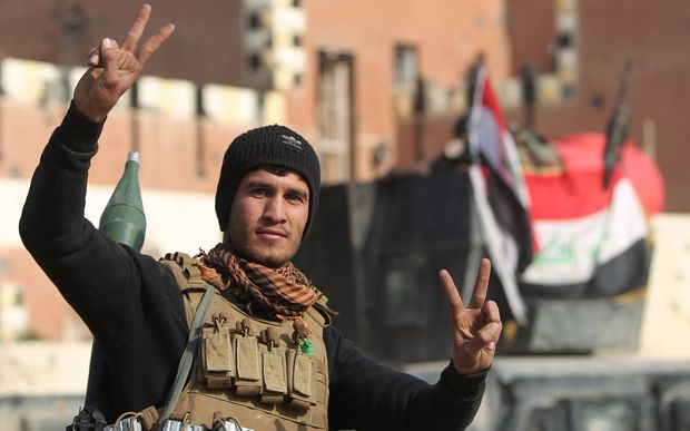 A member of Iraq's elite counter-terrorism service flashes the'V for victory sign