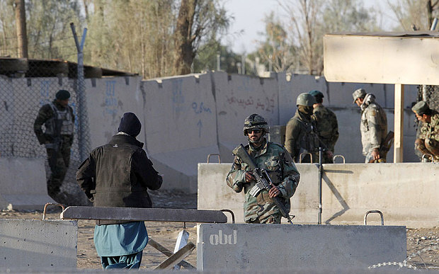 Afghan security forces stand guard at the entrance gate of Kandahar Airport where Taliban stormed on late Tuesday in Kandahar Afghanistan