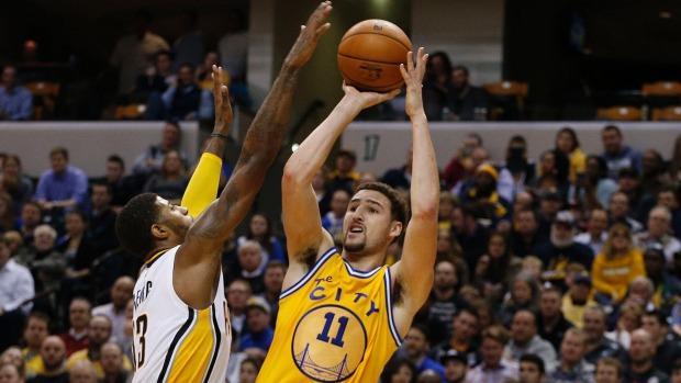 Golden State Warriors guard Klay Thompson takes a shot under pressure from the Indiana Pacers Paul George