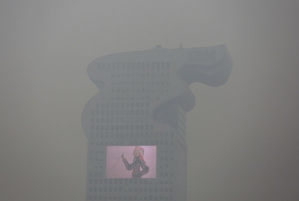 A building with a screen on it in Beijing on Tuesday was obscured by smog that led to the city’s top level of air pollution warning. Damir Sagolj  Reuters