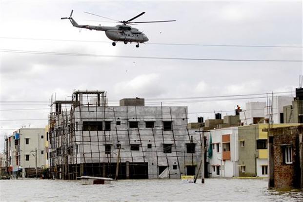 An Indian Navy helicopter drops food packets to people surrounded by floodwaters following heavy rains in Chennai Tamil Nadu on 2 December 2015