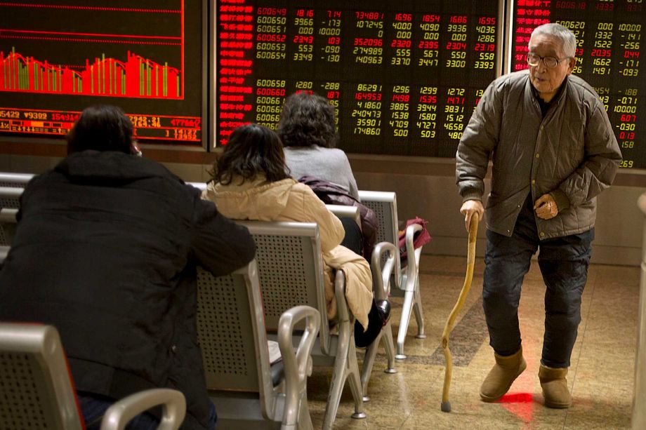 A Chinese investor walks through a brokerage house in Beijing Friday Dec. 4 2015. Asian stocks sank Friday extending a sell-off in world markets after Europe's central bank unveiled plans to stimulate the continent's ailing economy that fell short