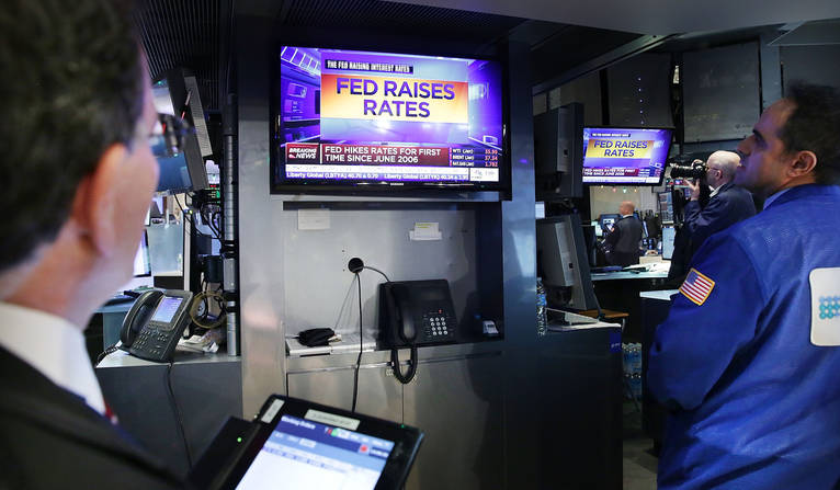 Traders wait on the floor of the New York Stock Exchange for the announcement that the Federal Reserve will raise interest rates. The Fed approved a quarter-point increase in its target funds rate the new target will go from 0 percent to 0.25 perc