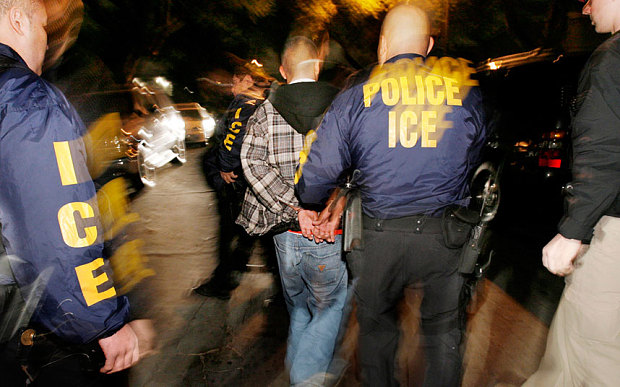 Immigration and Customs Enforcement officers arrest a suspect during a pre-dawn raid