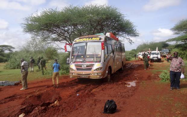 Kenyan security forces and others gather around the scene on an attack on a bus about 50 kilometers outside the town of Mandera near the Somali border in northeastern Kenya Saturday Nov. 22 2014. Somalia's Islamic extremist rebels al-Shaba