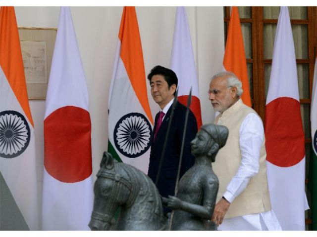 India's Prime Minister Narendra Modi walks with Japan's Prime Minister Shinzo Abe at Hyderabad House in New Delhi