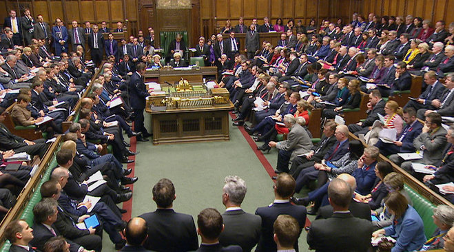 British Prime Minister David Cameron standing centre left talks to lawmakers inside the House of Commons in London during a debate on launching airstrikes against Islamic State extremists inside Syria Wednesday Dec. 2 2015. The parliamentary vote