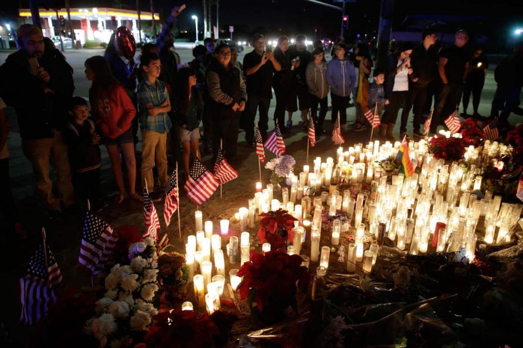 People pay respects at a makeshift memorial site honoring Wednesday's shooting victims Sunday Dec. 6 2015 in San Bernardino California