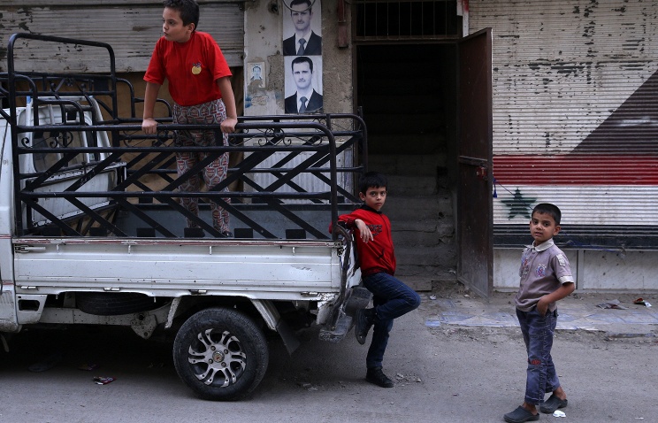 Local residents in a street in the Dahaniya neighborhood of the Syrian capital Damascus