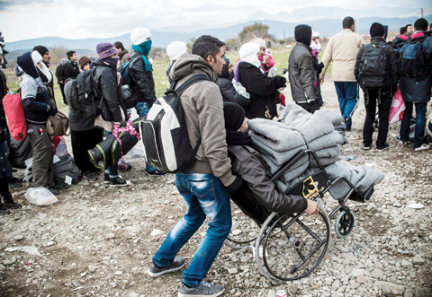 Migrants wait to enter the refugee camp after crossing the Greek Macedonian border near Gevgelija yesterday.— AFP