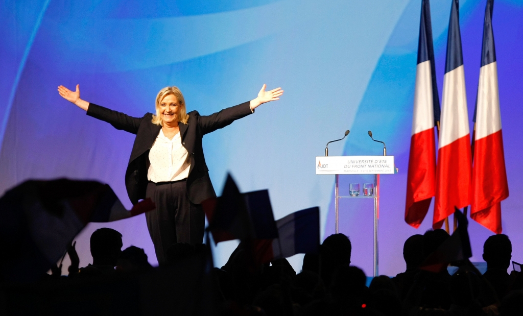 France’s far-right National Front president Marine Le Pen center surrounded by members waves to supporters after her speech during their meeting in Marseille southern France Saturday Sept. 6 2015