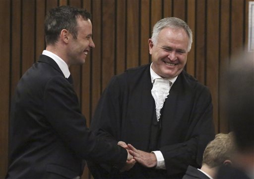 Oscar Pistorius left speaks with his defense lawyer Barry Roux at the High Court in Pretoria South Africa Tuesday Dec. 8 2015. Pistorius wants to take his case to the Constitutional Court challenging an appeals court that convicted him of murdering