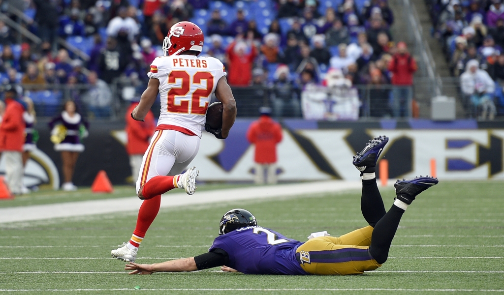 Kansas City Chiefs cornerback Marcus Peters runs past Baltimore Ravens quarterback Jimmy Clausen after intercepting Clausen's pass for a touchdown in the second half of an NFL football game Sunday Dec. 20 2015 in Baltimore. (AP