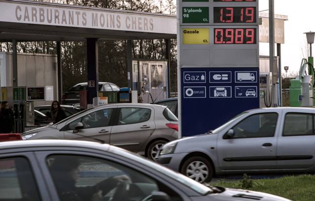 People gas up their car at a gas station in Bailleul northern France