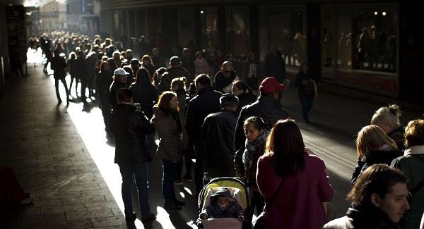 People line up to buy lottery tickets in Madrid today. Pic AP