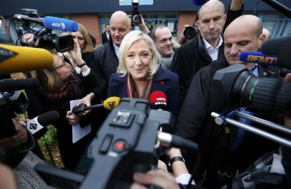 Marine Le Pen French National Front political party leader and candidate for the National Front in the Nord-Pas-de-Calais-Picardie region speaks to journalists as she leaves the polling station after casting her ballot in the second-round regional elect