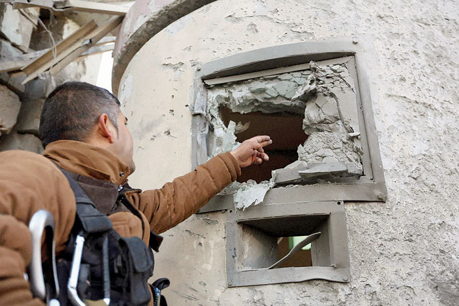 An Afghan security guard inspects the damage at the Spanish Embassy in Kabul Afghanistan on Saturday. Pic  AP