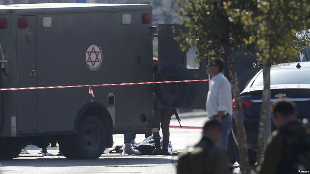 The body of a Palestinian who Israeli police said stabbed and wounded two security guards is seen on the ground near a military ambulance near the West Bank Jewish settlement of Ariel Dec. 24 2015