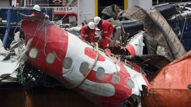 Workers are shown lifting the fuselage of Air Asia QZ8501