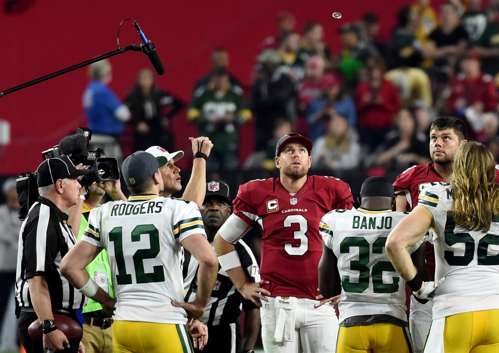 GLENDALE AZ- JANUARY 16 Quarterback Carson Palmer #3 of the Arizona Cardinals and quarterback Aaron Rodgers #12 of the Green Bay Packers watch the overtime coin toss in the NFC Divisional Playoff Game at University of Phoenix Stadium