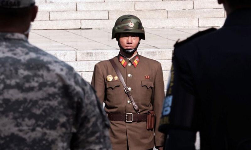 A North Korean guard stares at U.S. and Korean guards in front of Freedom House at the Demilitarized Zone between North and South Korea Nov. 1 2015. North Korea said it would consider abandoning its nuclear program in exchange for a signed peace treaty