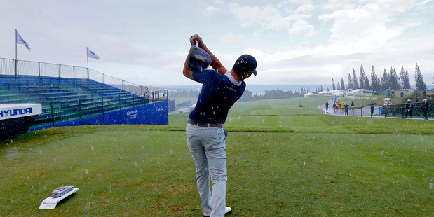 Danny Lee hits from the first tee during a rain shower at the Tournament of Champions golf pro-am