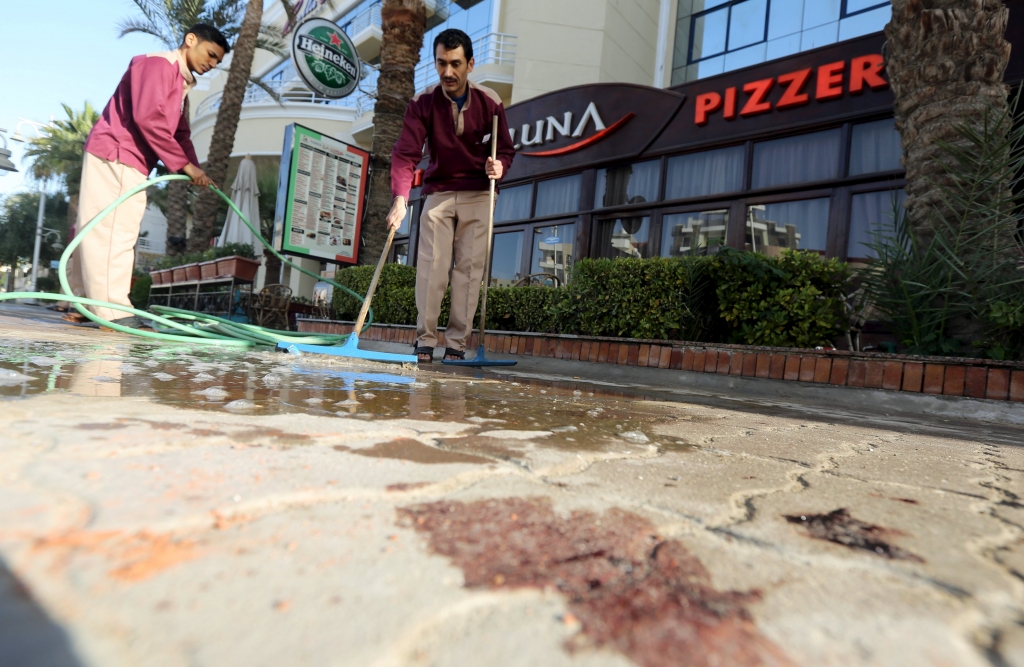 Cleaners try to clean blood stains near the entrance to Bella Vista Hotel in the Red Sea resort of Hurghada Egypt today. Two armed assailants attacked a hotel in the Egyptian Red Sea resort town of Hurghada yesterday wounding three foreign tourists Eg