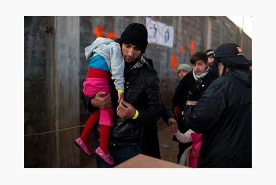 Afghan man with his daughter walks after they receive a wristband tags at Tabakika registration center Chios island Greece. The island now has a functioning system which aims to process new arrivals through regist