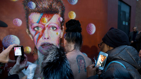 Fans pay tribute to David Bowie at a mural by artist Jimmy C in Brixton south London