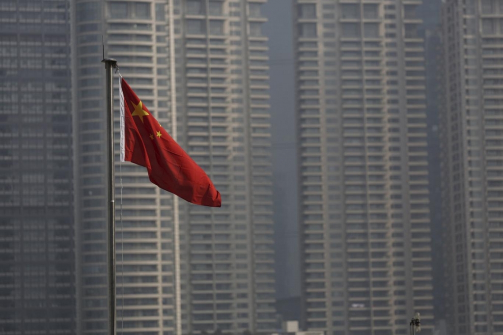 Chinese flag is seen in front of the financial district of Pudong in Shanghai China