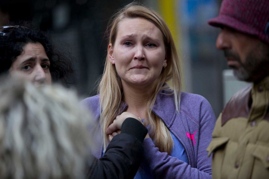 An Israeli woman reacts at the scene of a shooting attack in Tel Aviv Israel Friday Jan. 1 2016. A gunman opened fire at a popular bar in the central Israeli city killing two and wounding at least three others before fleeing the scene police said. P