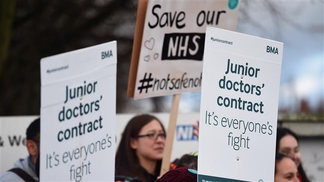 Demonstrators hold placards on the picket line outside Sandwell General Hospital in West Bromwich central England