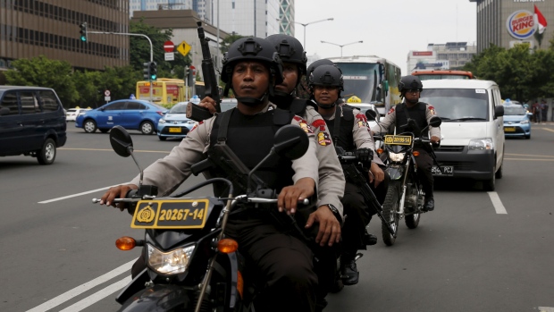 Indonesian policemen ride motorcycles as they patrol near the bomb blast site at Thamrin business district in Jakarta on Friday