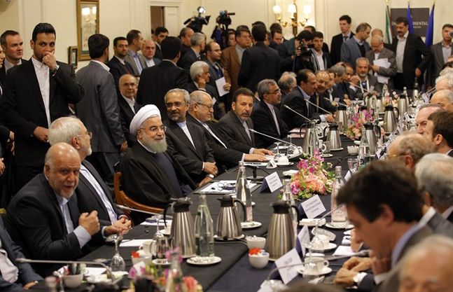 Iranian President Hassan Rouhani third left seated attends a meeting with French Economy Minister Emmanuel Macron and French business leaders in Paris Wednesday Jan. 27 2016. Rouhani says his first visit to Europe since the nuclear accord was signed