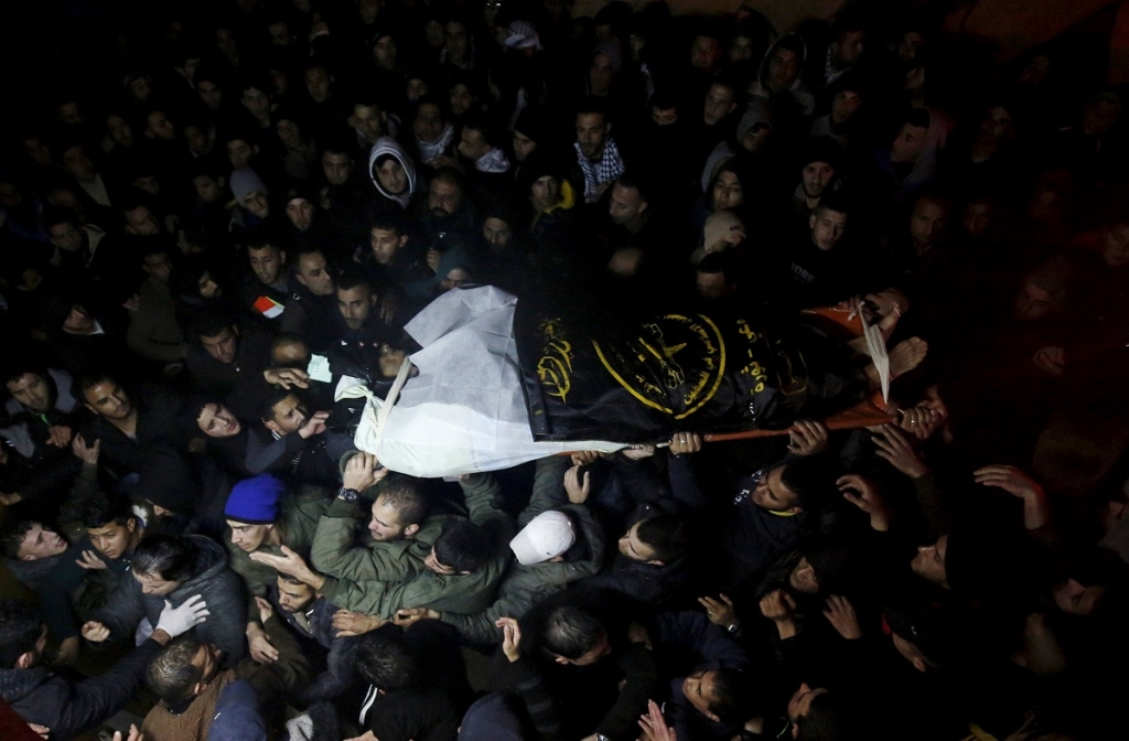 People carry the body of a Palestinian who allegedly carried out an attack against Israelis after his body was released by Israel and handed over to the Palestinian authorities in the West Bank city of Ramallah yesterday. – Reuters pic