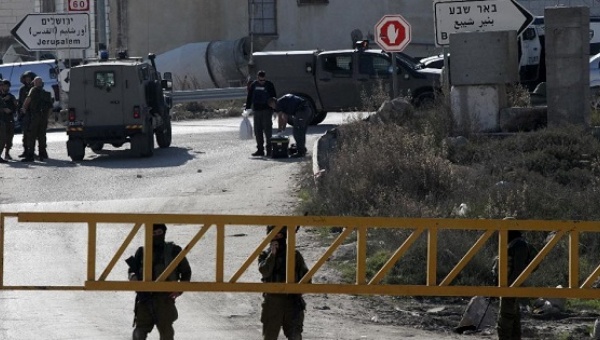 Israeli security forces stand guard at a checkpoint near the West Bank city of Hebron on Dec. 24 2015