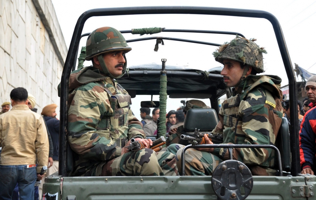 Indian army soldiers sit in an army vehicle outside Pathankot Air Force base following an encounter with militants on January 4. At least seven soldiers and four gunmen have been killed in the fighting that erupted at the air force station at Pathankot