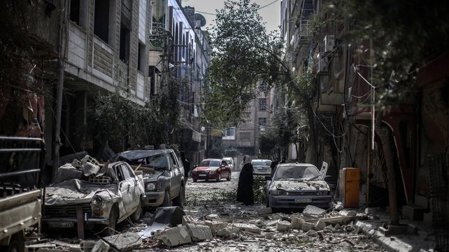 Locals inspect the aftermath of an airstrike by government forces in Douma on the outskirts of Damascus