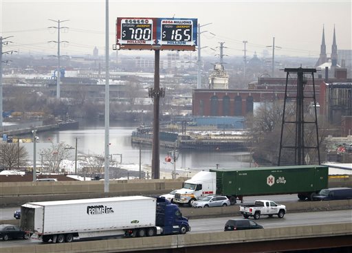 Motorists traveling on the interstate highway near downtown Chicago pass by an electronic billboard of the current jackpots for the Powerball and Mega Millions lotteries Thursday Jan. 7 2016 in Chicago