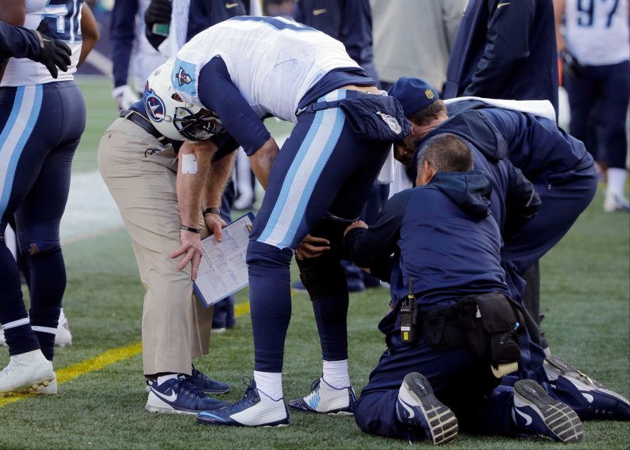 Tennessee Titans quarterback Marcus Mariota has a knee brace fitted on the sideline in the first half of an NFL football game against the New England Patriots Sunday Dec. 20 2015 in Foxborough Mass. Mariota did not return to the game