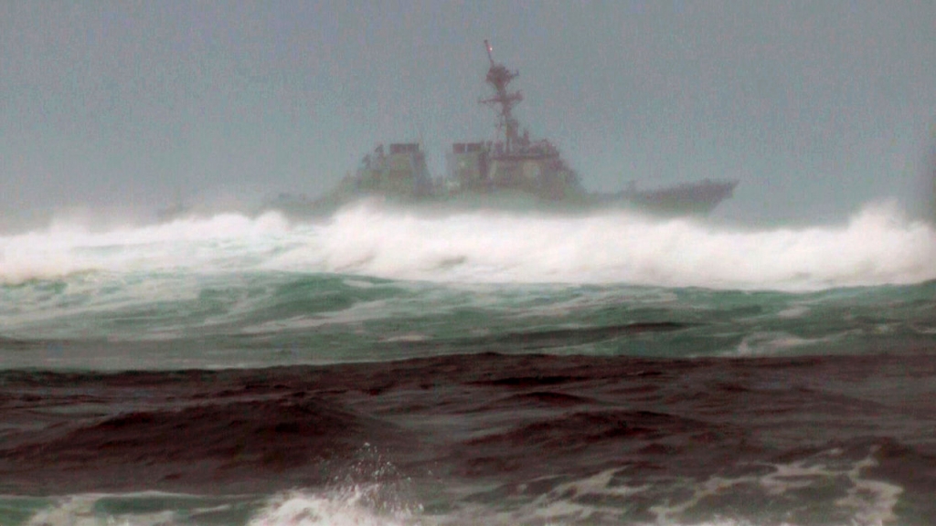 A search vessel cruises the waters off the beach at Haleiwa Hawaii on Friday. Two Marine helicopters carrying 12 crew members collided off the island of Oahu during a nighttime training mission and rescuers are searching a debris field in choppy waters