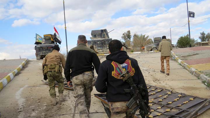 Iraqi pro-government forces walk towards military vehicles during battles with Islamic State group jihadists as they try to secure all the neighbourhoods of Ramadi the capital of Iraq's Anbar province about 110 kilometers west of the capital Baghda