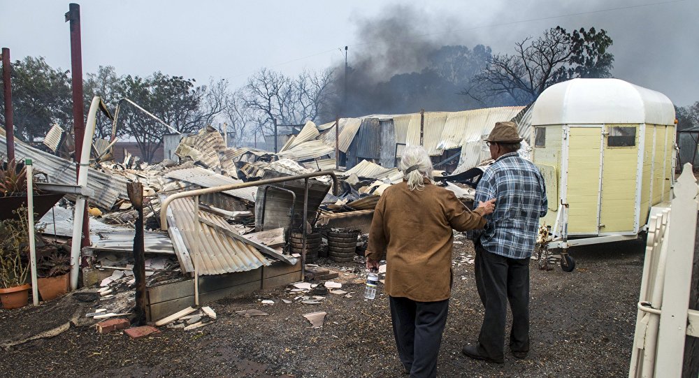 Property owners inspect their house that was destroyed by a bushfire near the town of Roseworthy located north of Adelaide South Australia