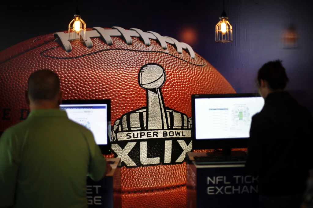 A mural of a football decorates the wall of an NFL Super Bowl XLIX ticket office as customers check for seating availability Saturday Jan. 31 2015 in Phoenix. The traditional path of Super Bowl tickets is this Tickets become more affordable as the