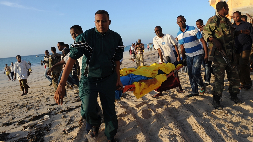 People carry away a dead body from Lido beach in Mogadishu after an attack on a beachfront restaurant