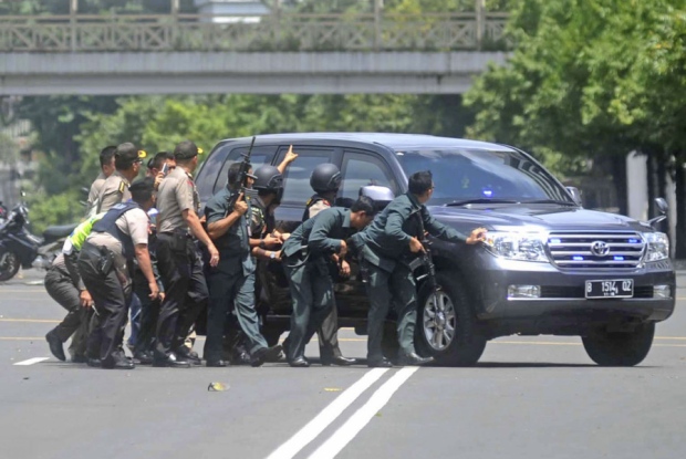 Police in Jakarta take cover during a gun battle with terrorists in the Indonesian capital