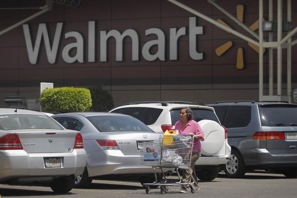 A shopper carts her purchases from a Wal Mart store in Mexico City